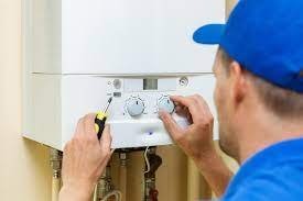 Engineer adjusting boiler controls during a service